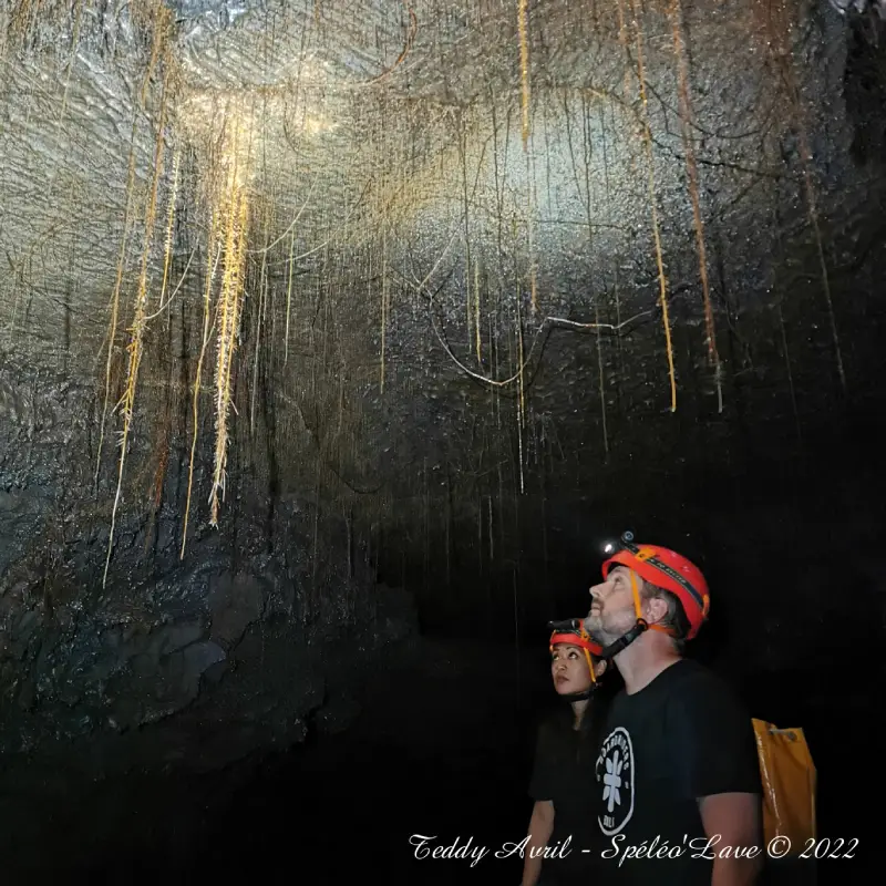 Petite voûte rocheuse et passage étroit éclairé par la lumière du jour.